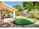 Manicured backyard featuring a private putting green, covered patio with dining set, and beautiful landscaping at 20615 N 55Th Ave, Glendale, AZ 85308