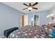 Bedroom featuring blue walls, ceiling fan, carpeted floor, and closet with storage at 20615 N 55Th Ave, Glendale, AZ 85308