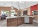 Bright kitchen featuring a central island with bar seating, and a view into the home's living spaces at 20615 N 55Th Ave, Glendale, AZ 85308