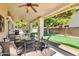 Inviting covered patio with ceiling fan, comfortable seating, and putting green view at 20615 N 55Th Ave, Glendale, AZ 85308