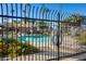 A black iron fence surrounds the community pool and sunbathing area at 2338 W Lindner Ave # 22, Mesa, AZ 85202