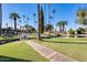 A sidewalk leads to a bridge over a small waterway with palm trees and grassy areas at 2338 W Lindner Ave # 22, Mesa, AZ 85202