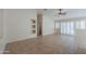 Open-concept living room with neutral walls, tile flooring, and large windows for natural light at 2433 E Hancock Trl, Casa Grande, AZ 85194