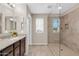 Bright bathroom with granite countertops, modern vanity, and tiled walk-in shower with glass door at 314 N 79Th Pl, Mesa, AZ 85207