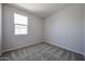 Minimalist bedroom with carpet, neutral walls, and a window providing natural light at 35295 W La Paz St, Maricopa, AZ 85138