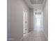 Bright hallway featuring tile flooring, neutral paint, and white doors leading to various rooms at 35295 W La Paz St, Maricopa, AZ 85138