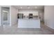 Bright kitchen features stainless steel appliances, granite countertops, an island, and tile floors at 35295 W La Paz St, Maricopa, AZ 85138