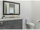 Elegant powder room with gray vanity, marble countertop, modern fixtures, and decorative patterned floor tiles at 3808 E Fairmount Ave, Phoenix, AZ 85018