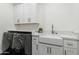 Modern laundry room featuring front-load washer and dryer, white cabinets, and marble countertops at 3808 E Fairmount Ave, Phoenix, AZ 85018