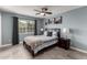 Comfortable bedroom with blue walls, ceiling fan, and natural light from a large window at 3923 S Dorsey Ln, Tempe, AZ 85282