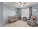 Cozy Bedroom with soft blue walls, crib, and a comfortable rocking chair near the window at 3923 S Dorsey Ln, Tempe, AZ 85282