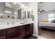 Bathroom with double sink vanity, well-lit mirror and access to the main bedroom at 3932 N 306Th Ln, Buckeye, AZ 85396