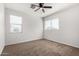 Comfortable carpeted bedroom with two windows and ceiling fan at 3932 N 306Th Ln, Buckeye, AZ 85396