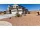 Exterior view of a two-story home featuring a three-car garage and desert landscaping at 3932 N 306Th Ln, Buckeye, AZ 85396