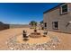 Backyard firepit area with seating, surrounded by gravel and a block wall fence for privacy at 3932 N 306Th Ln, Buckeye, AZ 85396