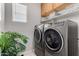 Bright laundry room with modern washer and dryer, upper cabinets and window at 3932 N 306Th Ln, Buckeye, AZ 85396