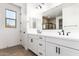 Bathroom featuring dual sinks, white cabinetry, and modern black hardware at 40546 W Michaels Dr, Maricopa, AZ 85138