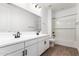 Double sink bathroom with white cabinets, tile flooring, and soaking tub at 40546 W Michaels Dr, Maricopa, AZ 85138