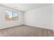 Cozy bedroom with neutral carpet, window, and freshly painted white walls at 40546 W Michaels Dr, Maricopa, AZ 85138