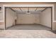 This garage has an electric door, concrete floor, and neutral paint at 40546 W Michaels Dr, Maricopa, AZ 85138