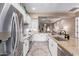 Modern kitchen featuring white cabinets, stainless steel appliances, granite countertops, and a view into the living room at 4241 N Pebble Creek Pkwy # 28, Goodyear, AZ 85395