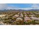 Wide aerial shot showcases neighborhood homes, desert landscaping, and mountain views in the distance at 4801 E Quien Sabe Way, Cave Creek, AZ 85331