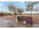 Park bench with trash can on a wet concrete path surrounded by trees and vegetation at 4801 E Quien Sabe Way, Cave Creek, AZ 85331