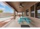 Covered patio featuring a light blue picnic table, ceiling fan, and access to the pool area for outdoor relaxation at 4801 E Quien Sabe Way, Cave Creek, AZ 85331