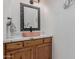 Charming powder room with a decorative mirror, granite countertops, and wood cabinets at 4801 E Quien Sabe Way, Cave Creek, AZ 85331