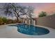 Private pool featuring tile accents, waterfall feature, and lush desert landscaping with a large shade tree at 4801 E Quien Sabe Way, Cave Creek, AZ 85331