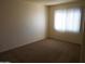 Carpeted bedroom featuring a window, natural light, and a neutral color palette, offering a tranquil retreat at 5221 N 42Nd Ln, Phoenix, AZ 85019