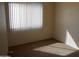 Bright bedroom with neutral carpet, large window with blinds, offering a clean and comfortable space at 5221 N 42Nd Ln, Phoenix, AZ 85019