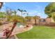 Backyard with lush landscaping, green turf, and a resort-style pool with water feature at 5615 W Tonopah Dr, Glendale, AZ 85308