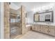 A bright bathroom with a glass-enclosed shower, soaking tub, and vanity with decorative mirrors at 5615 W Tonopah Dr, Glendale, AZ 85308