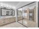 An elegant bathroom with a double vanity, decorative mirrors, and a glass-enclosed shower at 5615 W Tonopah Dr, Glendale, AZ 85308