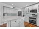 Well-lit kitchen showcasing white cabinetry, stainless steel appliances, and a convenient center island for meal prep at 5615 W Tonopah Dr, Glendale, AZ 85308