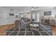 Cozy living room with a plush gray sectional sofa, hardwood floors, and a seamless flow to the kitchen at 5615 W Tonopah Dr, Glendale, AZ 85308