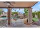 Covered patio with view of pool and palm trees, perfect for outdoor entertaining at 5615 W Tonopah Dr, Glendale, AZ 85308