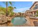 Backyard with a lush tropical pool featuring a water feature and ample tanning space at 5615 W Tonopah Dr, Glendale, AZ 85308