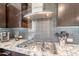 Close-up of the kitchen featuring stainless steel appliances, granite countertops, and gray tile backsplash at 631 E Peach Tree St, Queen Creek, AZ 85140