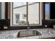 Kitchen sink with granite countertops and a window view of the outdoors, adding natural light and charm at 631 E Peach Tree St, Queen Creek, AZ 85140