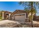 A tan stucco home featuring a three-car garage, desert landscaping, and a charming front porch area at 6829 S 58Th Ave, Laveen, AZ 85339