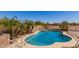 Private backyard pool with rock features and surrounded by lush tropical landscaping at 6829 S 58Th Ave, Laveen, AZ 85339