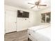 Bright bedroom featuring wood-look floors, a ceiling fan, and a mounted television at 6842 N 10Th Pl, Phoenix, AZ 85014