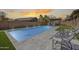 Resort-style backyard with a sparkling pool, artificial turf, stylish lounge chairs, and a charming pergola for relaxation at 7317 W Southgate Ave, Phoenix, AZ 85043