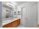 Neutral-toned bathroom with a single sink vanity, a large mirror, and white cabinets at 7317 W Southgate Ave, Phoenix, AZ 85043