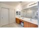 Bright bathroom features a double sink vanity, patterned floor, and a large mirror at 7317 W Southgate Ave, Phoenix, AZ 85043