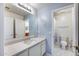 Bright bathroom features a sink, white countertops and blue accent wall with cross decor at 7317 W Southgate Ave, Phoenix, AZ 85043