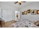 Bright bedroom features wood floors, neutral walls with artwork, and ensuite bathroom access at 7317 W Southgate Ave, Phoenix, AZ 85043