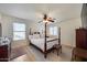 Bright bedroom featuring a four-poster bed, ceiling fan, and neutral color scheme at 7317 W Southgate Ave, Phoenix, AZ 85043